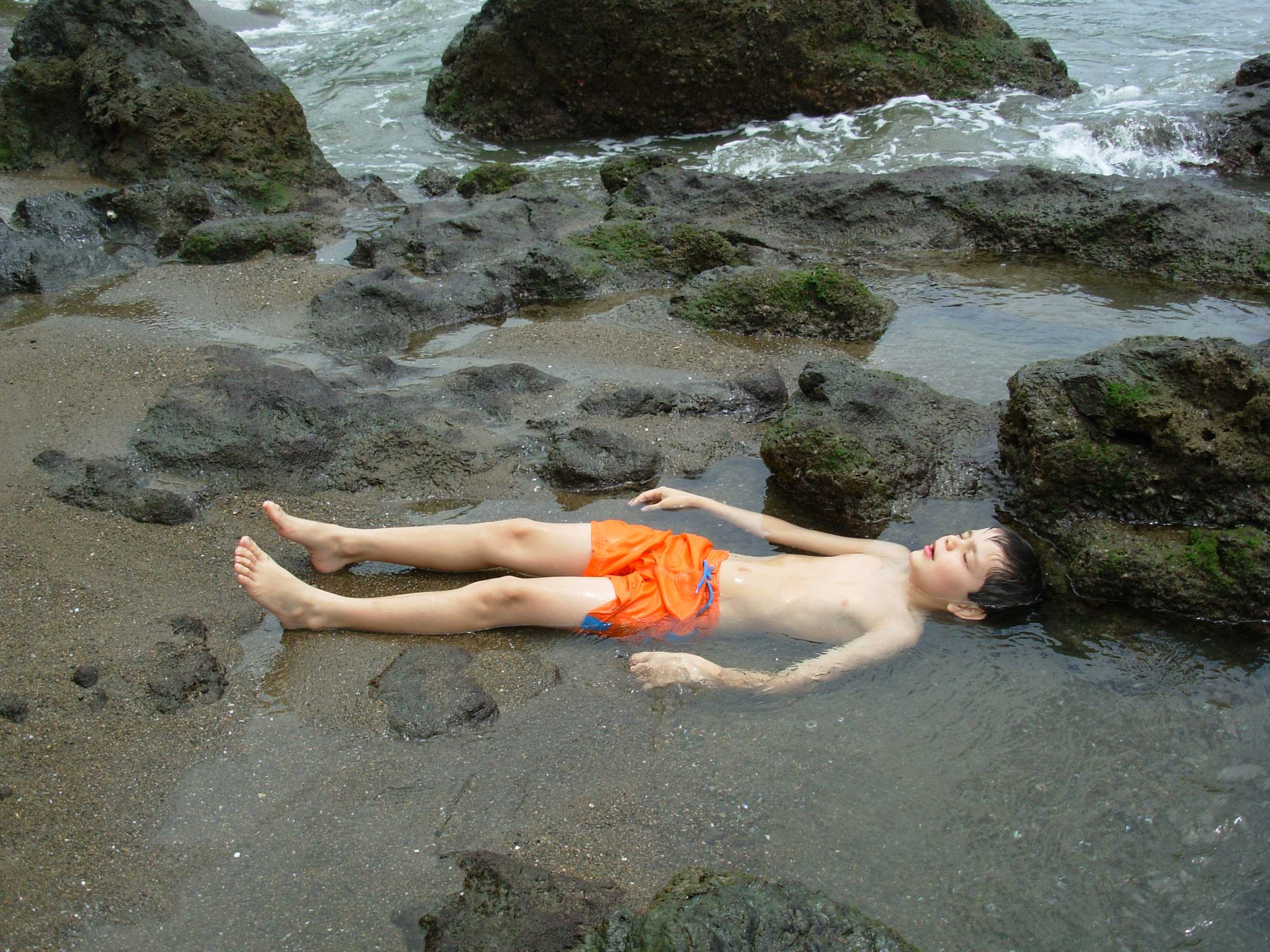 A child lying down at the beach
