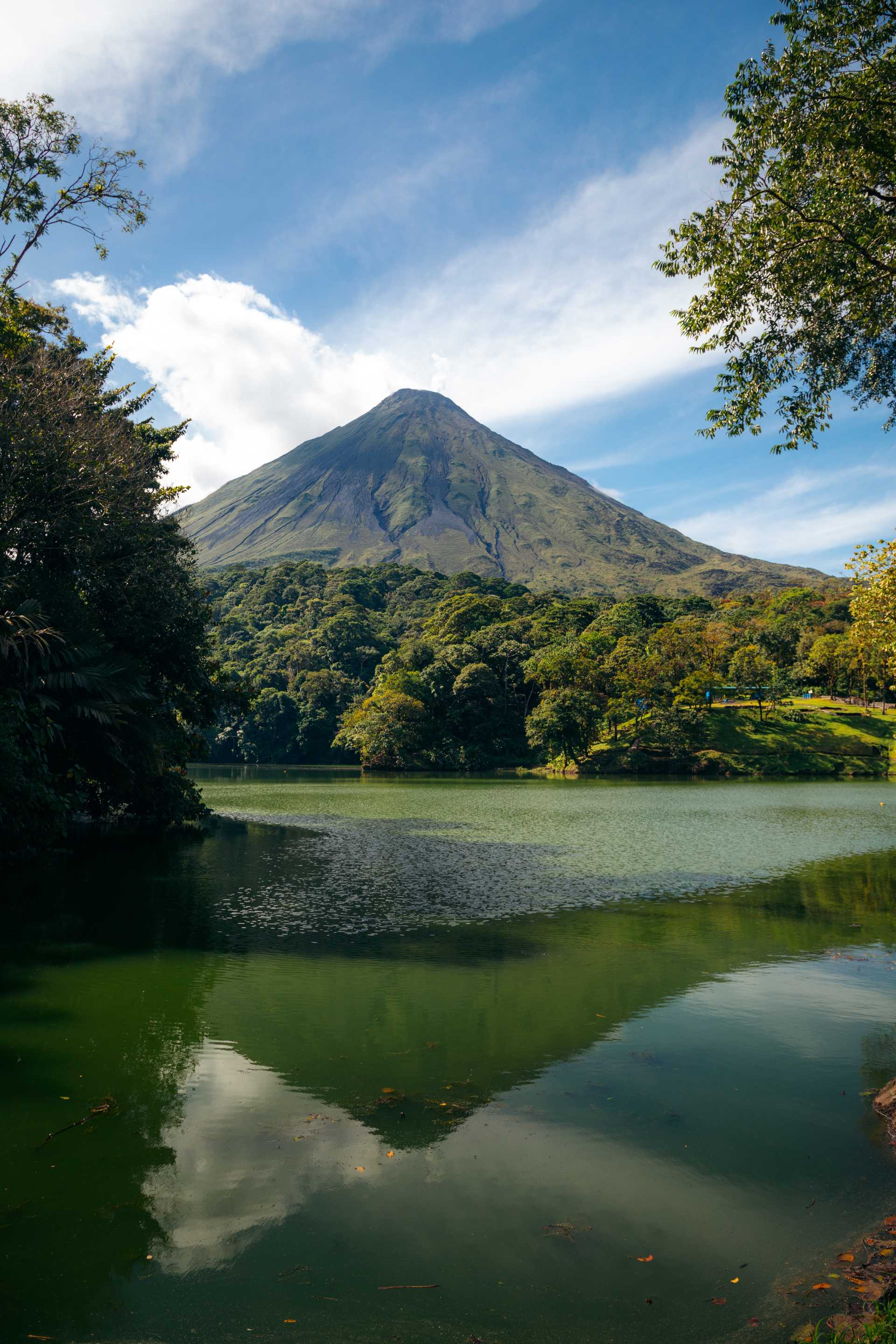 Arenal Volcano from a river surrounded by trees