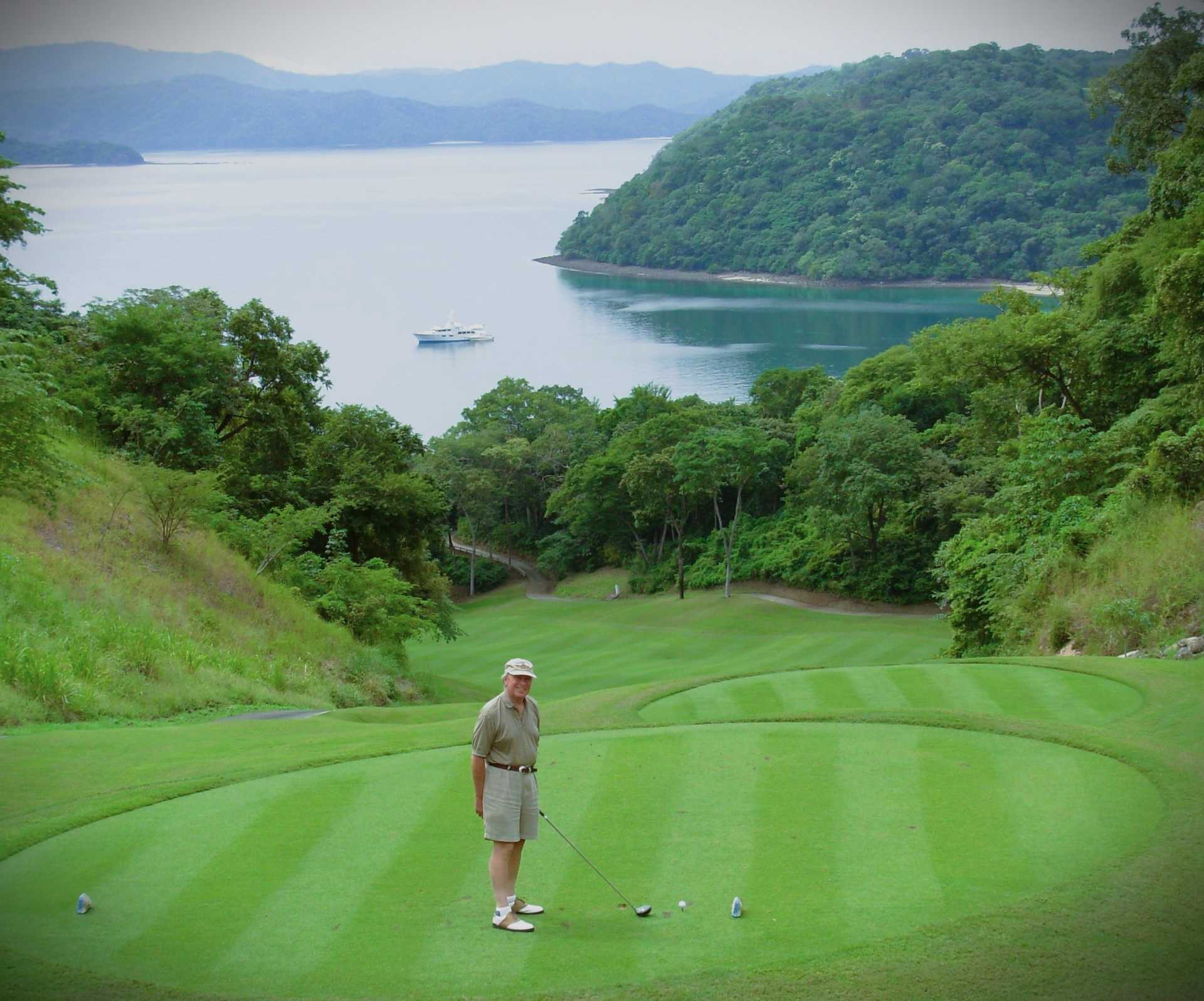 An elderly man playing golf near the jungle